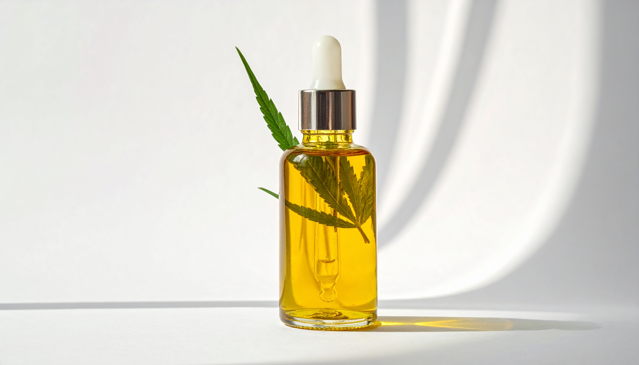 glass bottle of golden hemp extract oil with dropper backlit showing amber clarity - Steve's Goods CBD