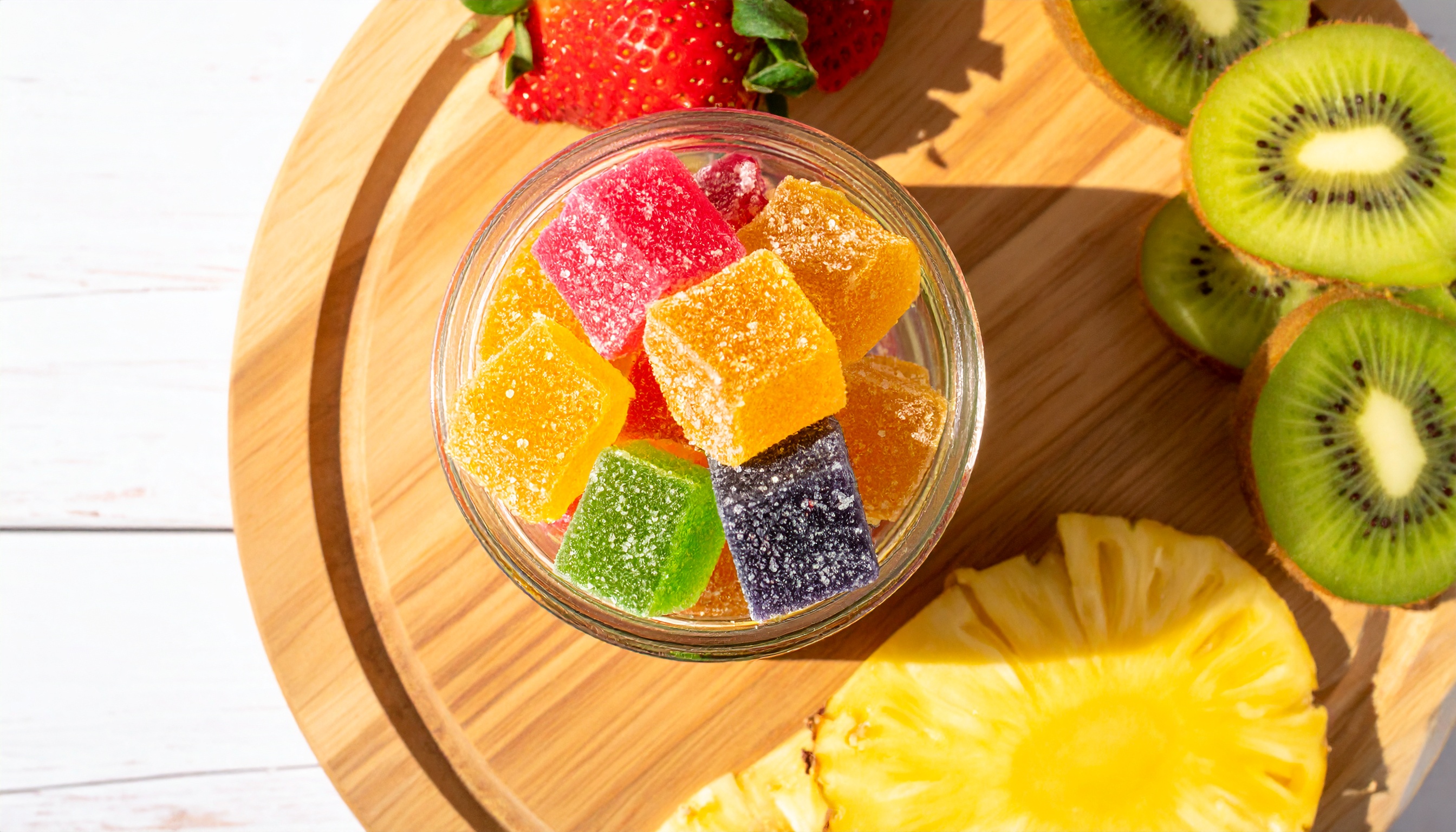 overhead flat lay of assorted cube shaped sugar coated cbd gummies in a glass ja - Steve's Goods