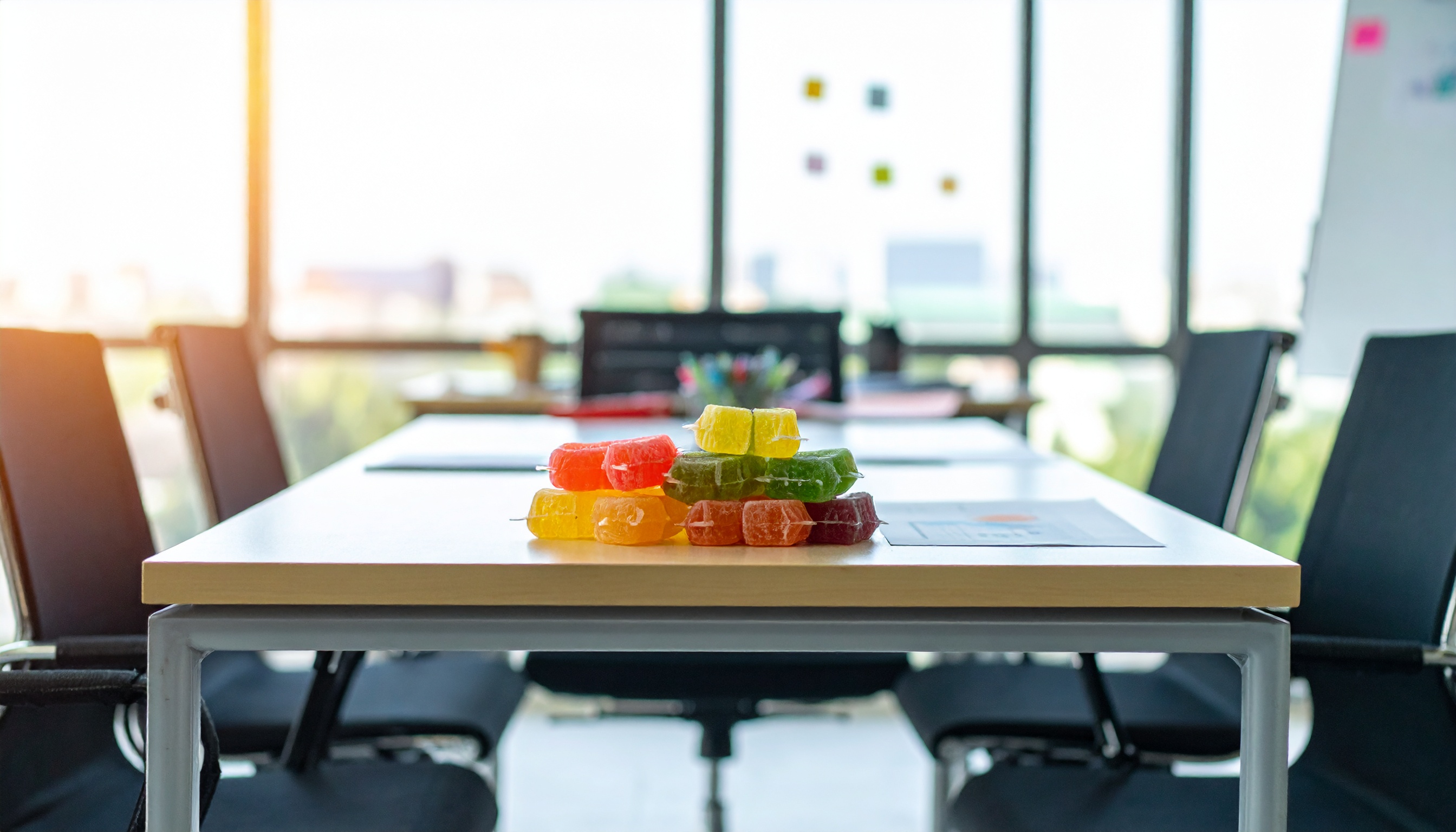 stack of gummy packages on a professional conference table business meeting setup - Steve's Goods CBD