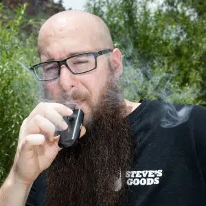 Steve smoking a CBD vape cartridge outside wearing a Steve's Goods T-shirt